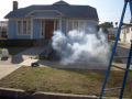 Satellite falls creating smoke in front of house Image